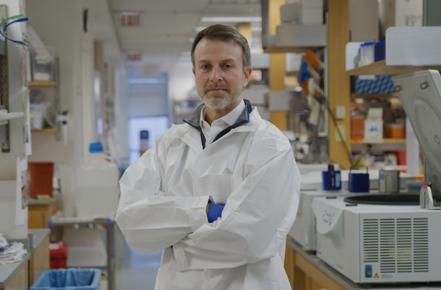 e john wherry stands with hands crossed in a lab