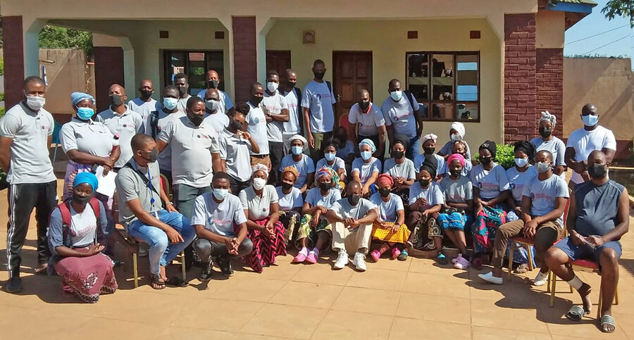 Group of people wearing masks outside a building in Malawi.