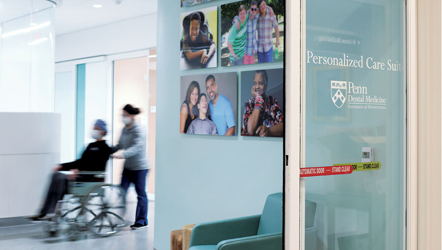 Dental patient in a wheelchair being pushed into the Penn Dental Medicine Personalized Care Suite.