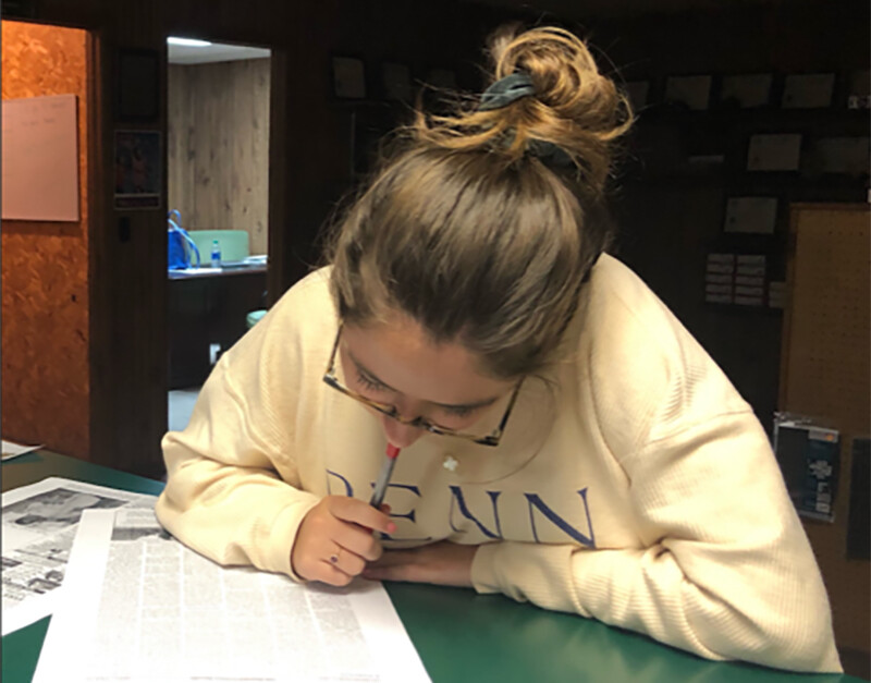 Celia Kreth reading&nbsp; papers in an office in Arkansas.