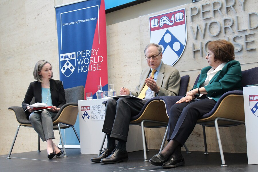 Three people seated on stage at Perry World House.