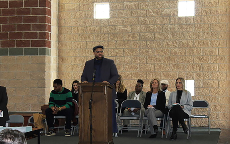 A person speaks at a podium at a graduation ceremony.