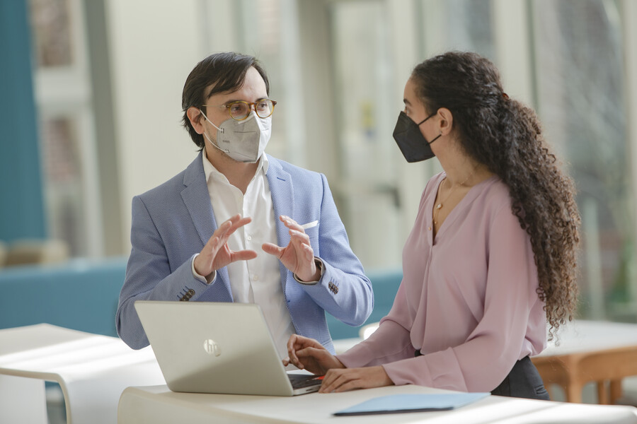 Dental professor Alonso Carrasco-Labra speaks with administrative coordinator Hala Baradi