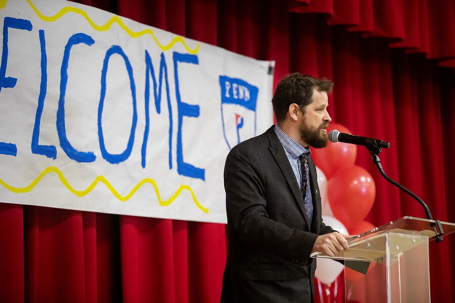Aaron Gerwer speaks in microphone at podium