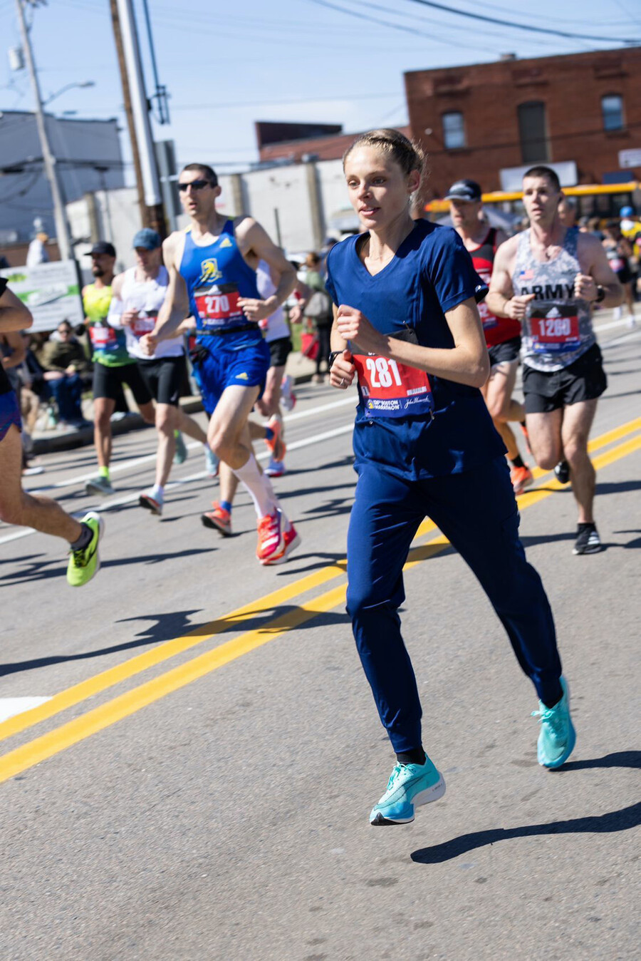 Samantha Roecker running in the Boston Marathon, with many runners around her. She wears bib number 281.