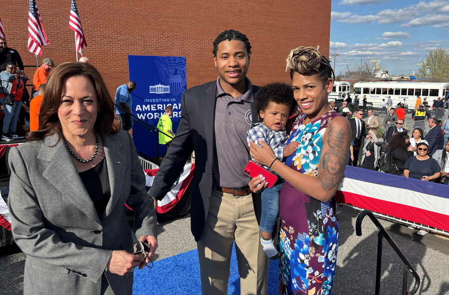 Vice President, Kamala Harris stands at a ceremony with William Griffin and his wife, who is holding their son.