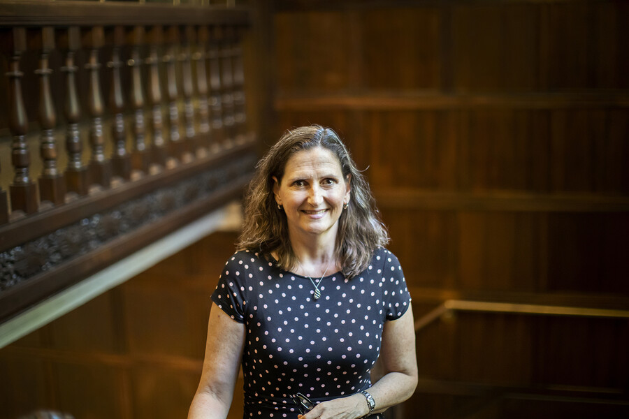 Chenoa Flippen smiles at the camera in a wood-paneled stairway