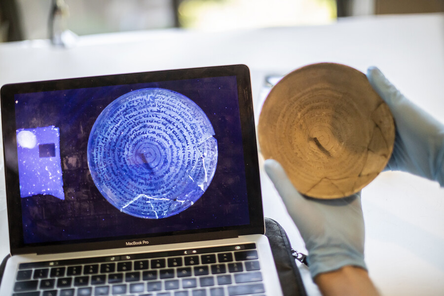 Simcha Gross examines an incantation bowl with uv light