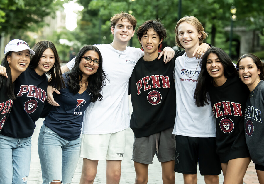 Eight high school students smile for the camera on Penn’s campus.