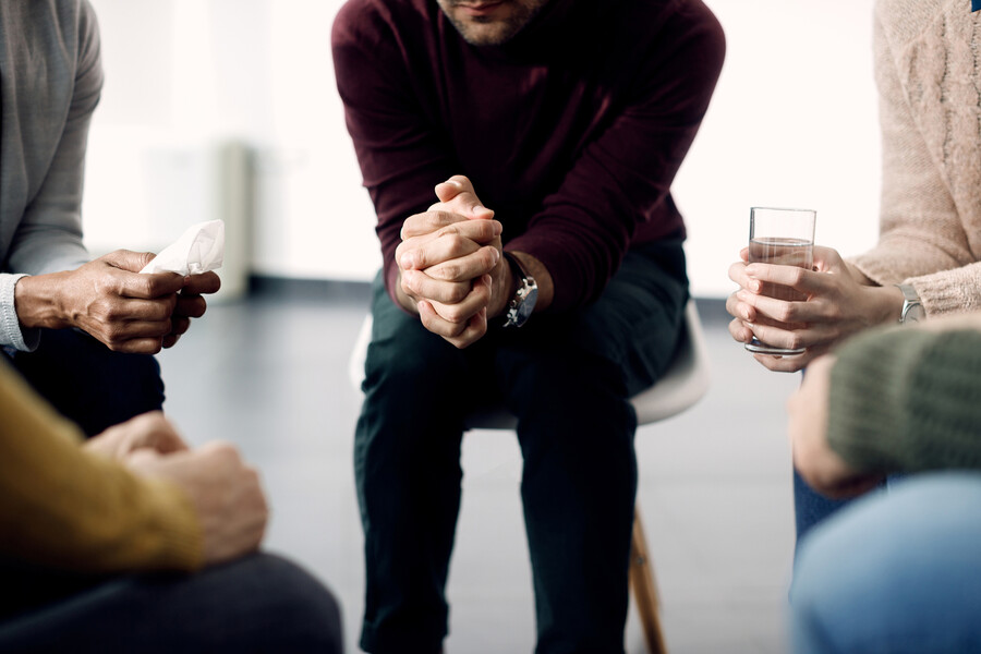 Four people seated in a support group setting.