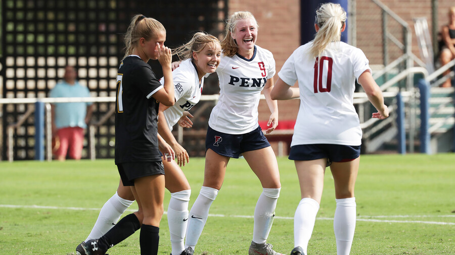 Lawton celebrates with two teammates during a game.