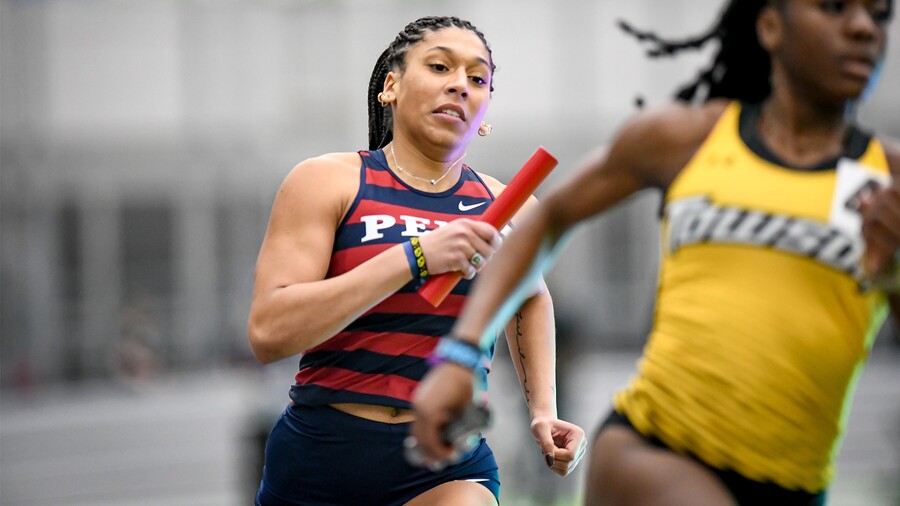 Sprinter Isabella Whittaker runs with a baton in her hand during a race.