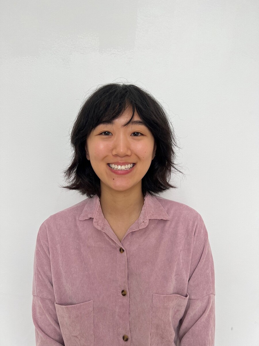 Hope Cho, in a rose colored blouse against a white background, smiles at the camera.