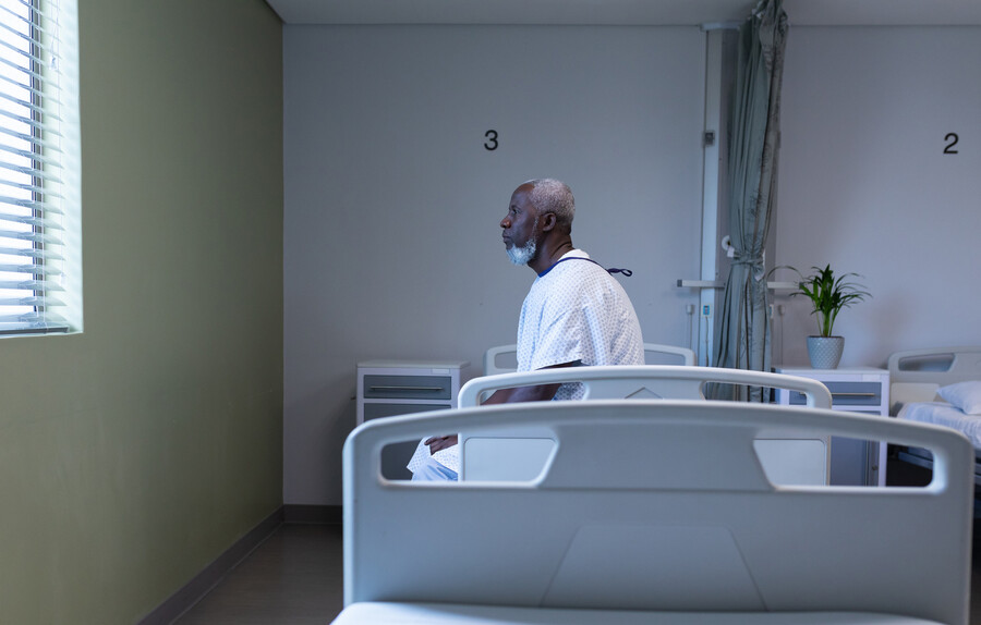 African American patient sitting on a hospital bed.