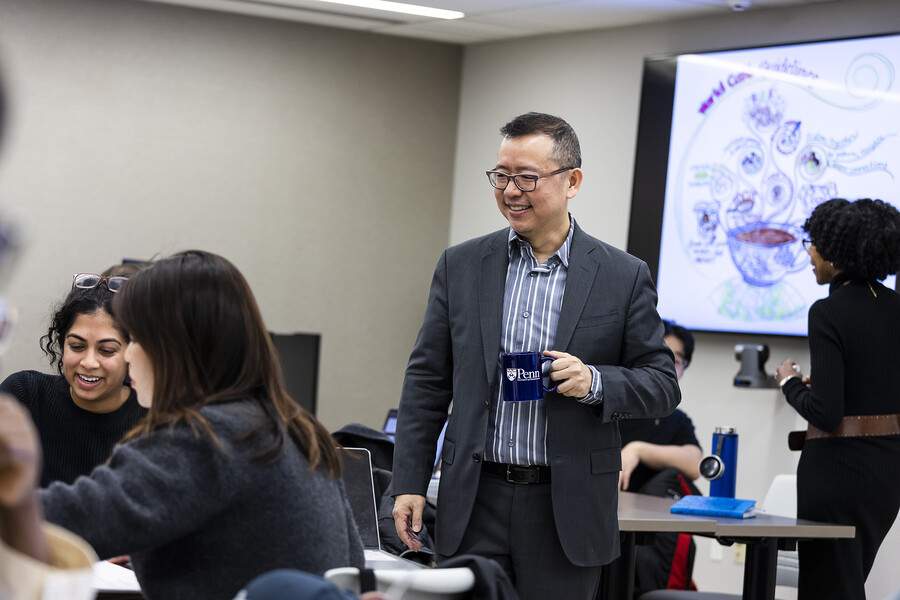 Chao Guo stands in a room with SP2 students.