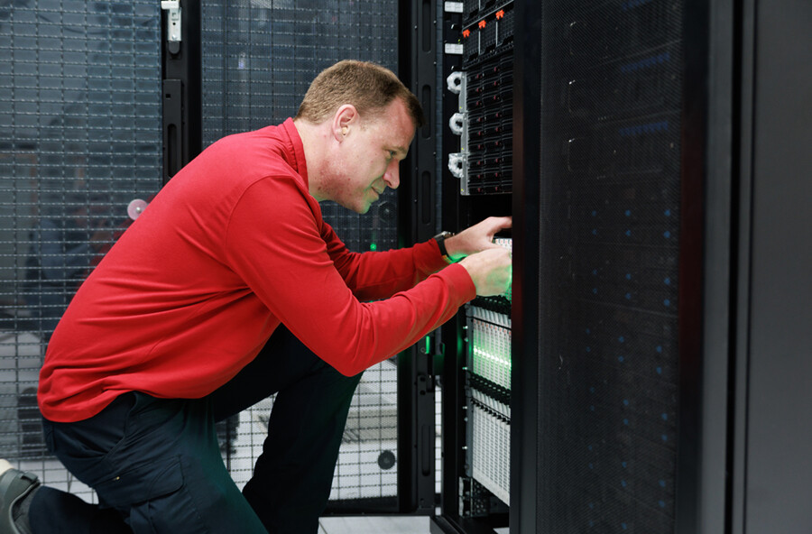 Gregory Bowman kneeling down in front of a server.
