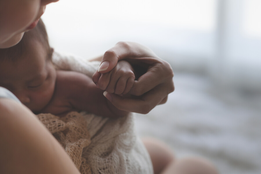 Parent holding newborn baby.