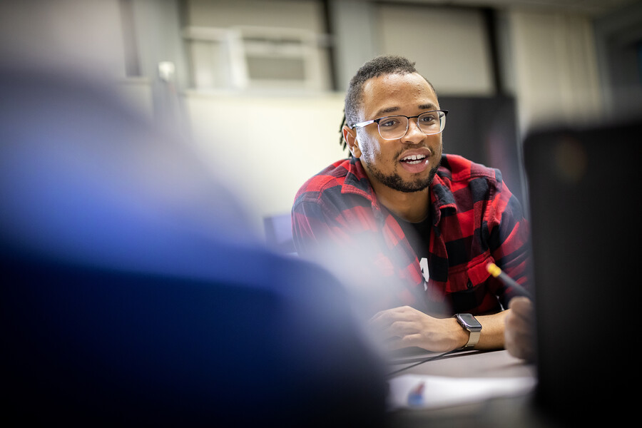 tamir harper in lea school, sitting at a table with students