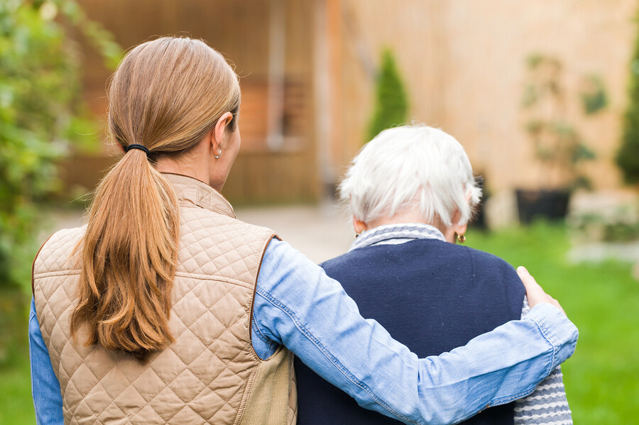 A person walking with an elderly person.
