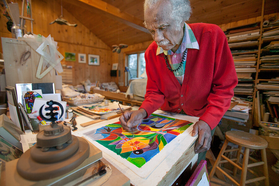 Ashley Bryan painting in his studio.