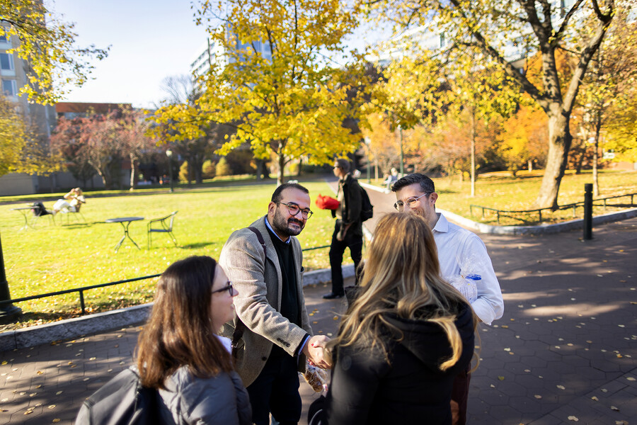 Harun Kucuk shakes hands with people on Locust Walk
