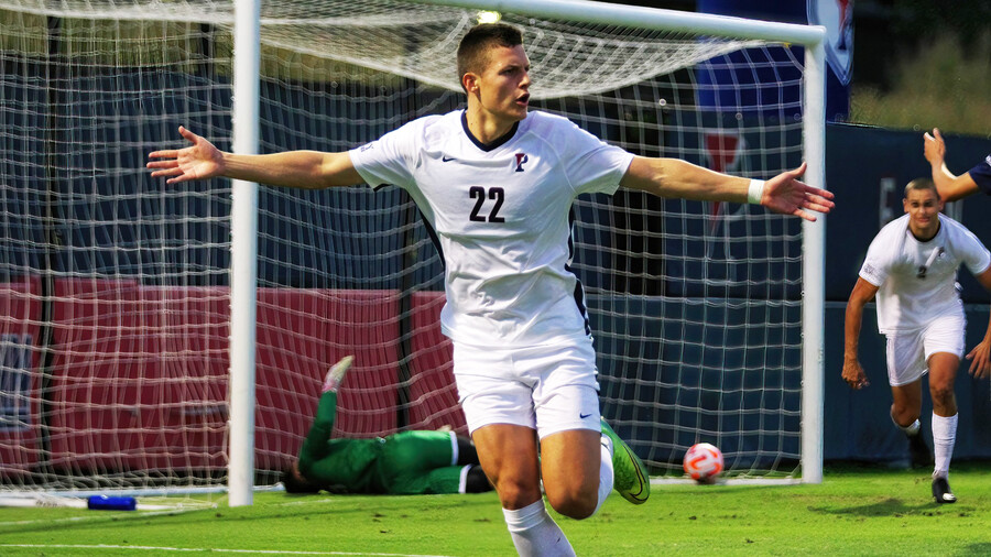 Stas Korzeniowski celebrates with his arms outstretched after scoring a goal.