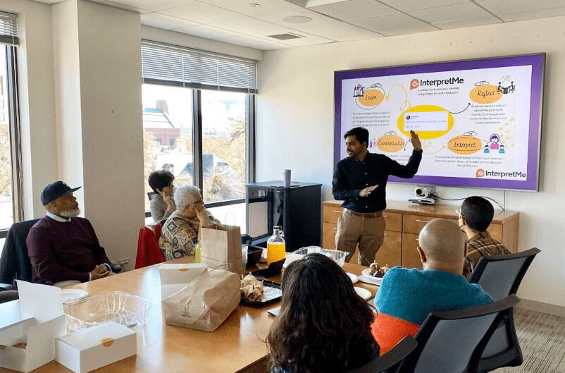 Siva Mathiyazhagan presenting at a smartboard.