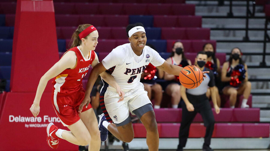 Jordan Obi pushes the ball down the court while guarded by a defender.