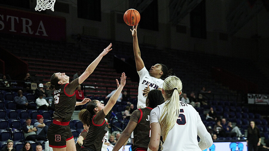 Jordan Obi lays the ball over the hands of two defenders.