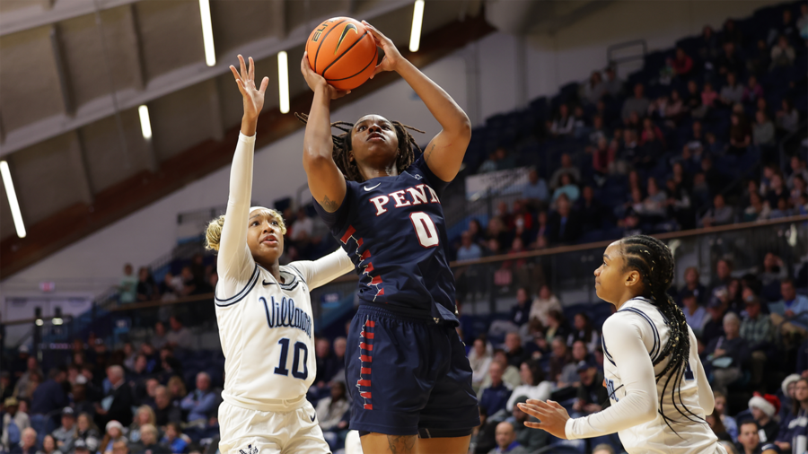 Jordan Obi shoots the ball while being guarded by two Villanova defenders.