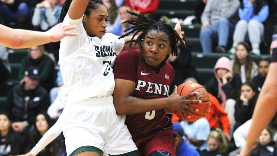 Jordan Obi makes a move to the basketball with the ball while being guarded by a defender.