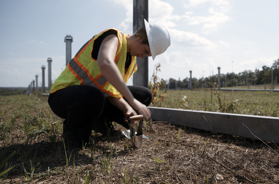 Hannah Win takes soil samples at a solar site.