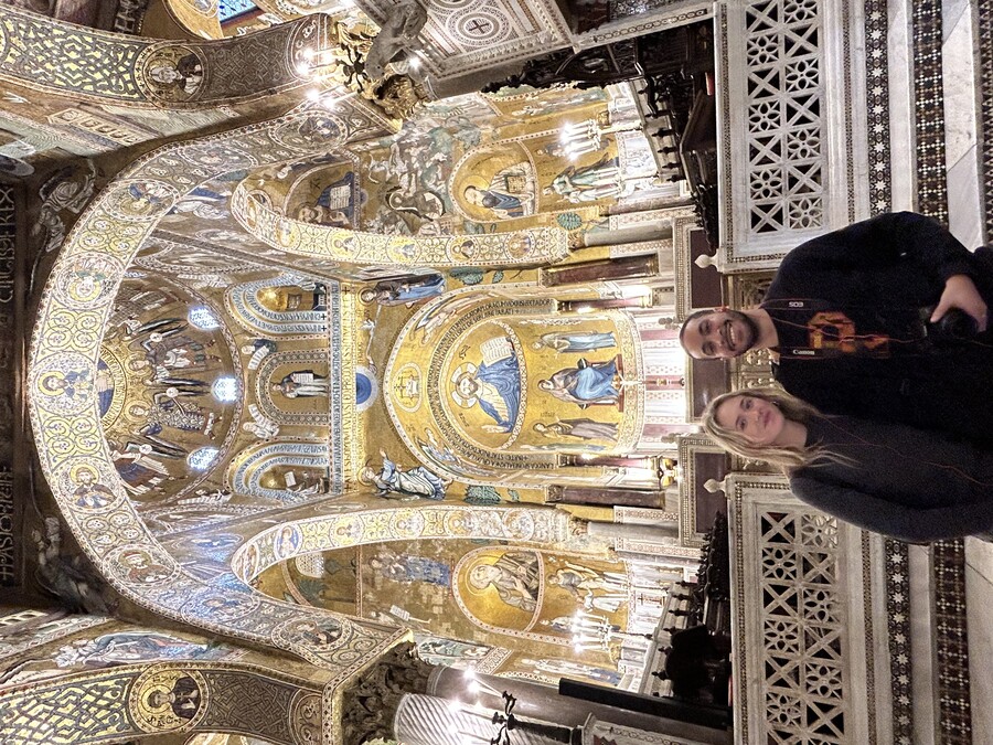 Amelia Hemphill and Oscar Vasquez pose under an ornate gilded archway in the Palatine Chapel in the Royal Palace in Palermo. 