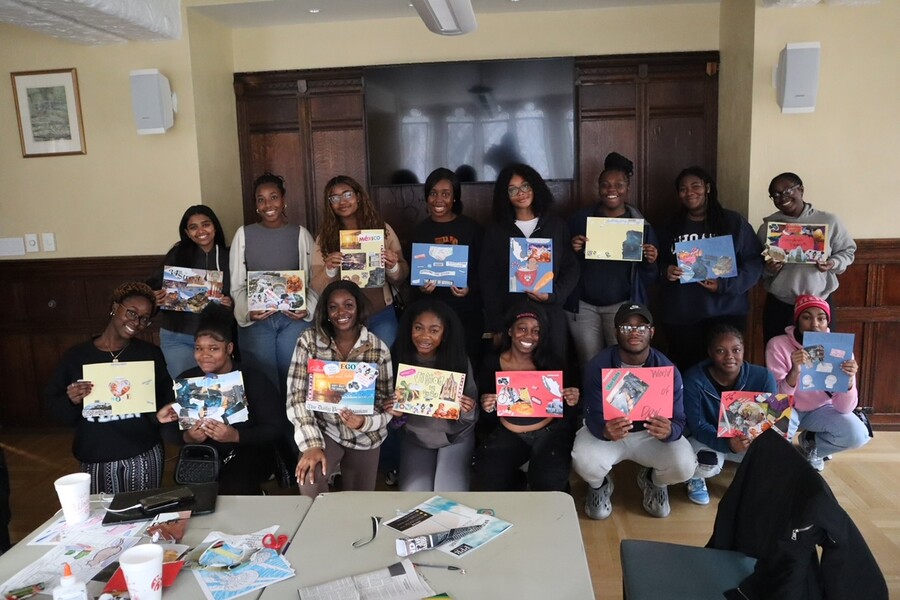 Students hold up pieces of paper showing a vision board.