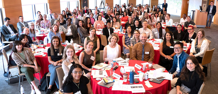 A large group of people seated at tables at a conference.