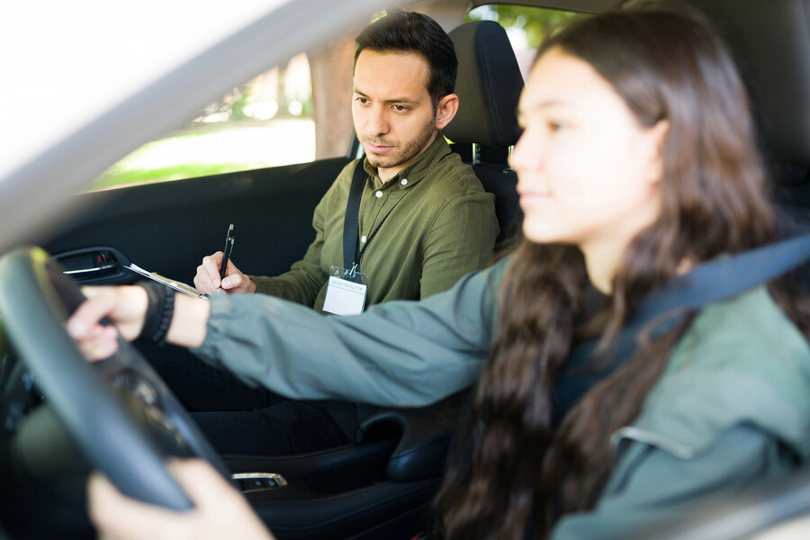 A teen driver with a driving instructor.