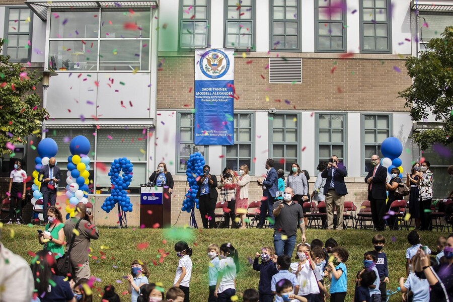Students and officials gather under falling confetti to celebrate the Sadie Tanner Mossell Alexander University of Pennsylvania Partnership School
