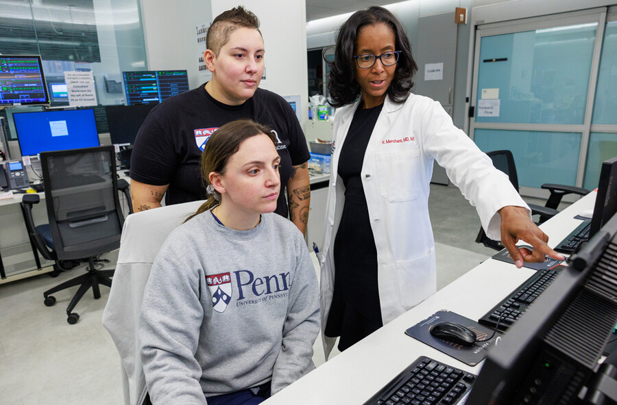 Raina Merchant and two staffers in an office looking at a computer at Penn Medicine.