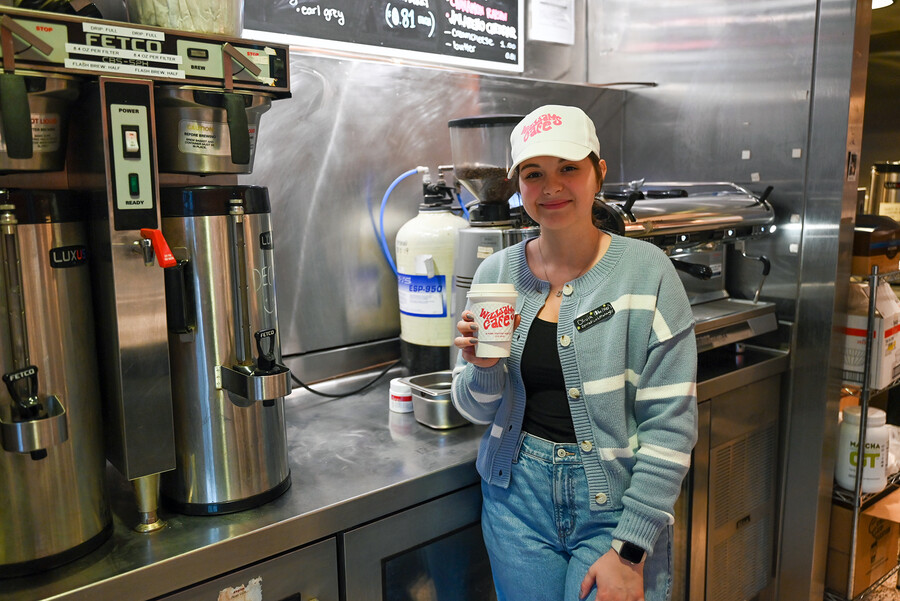 Olivia Turman holding a Williams Cafe coffee cup at the cafe.