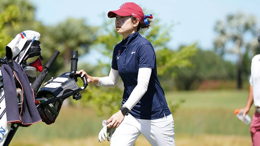 Julie Shin pushes her golf bag during a match.