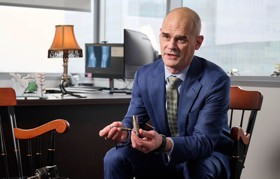 Benjamin Potter holding a piece of prosthetic hardware.