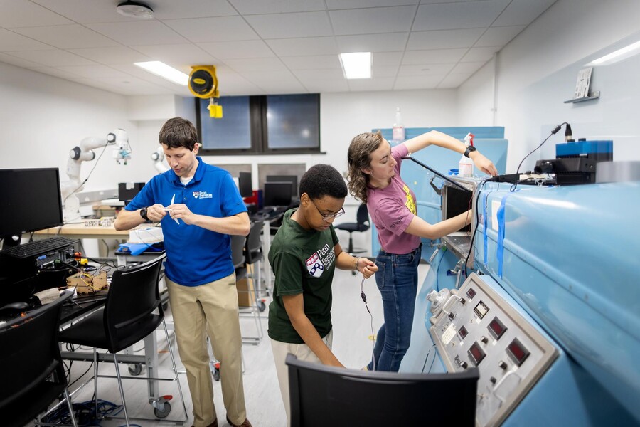 Peter Bruno, Ngaatendwe Manyika, and Lorena Grundy working on a wind turbine.