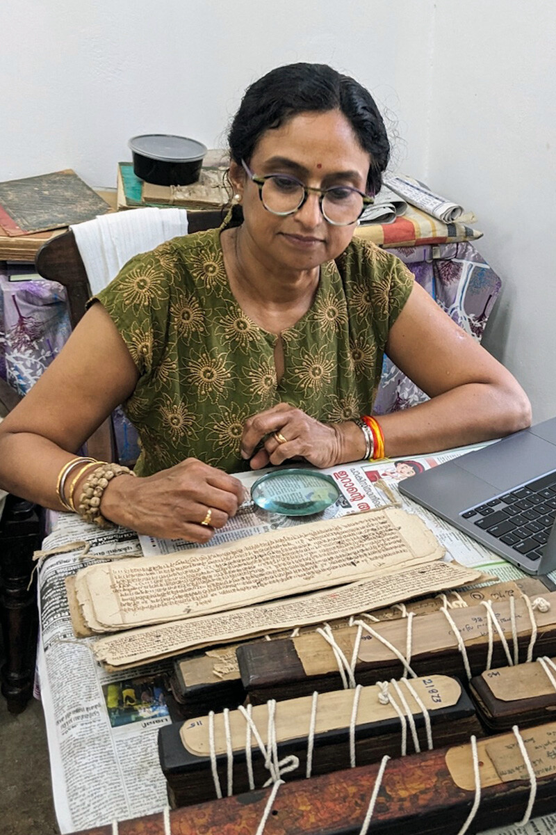 Priya Nambrath looks at medieval texts with a magnifying glass.