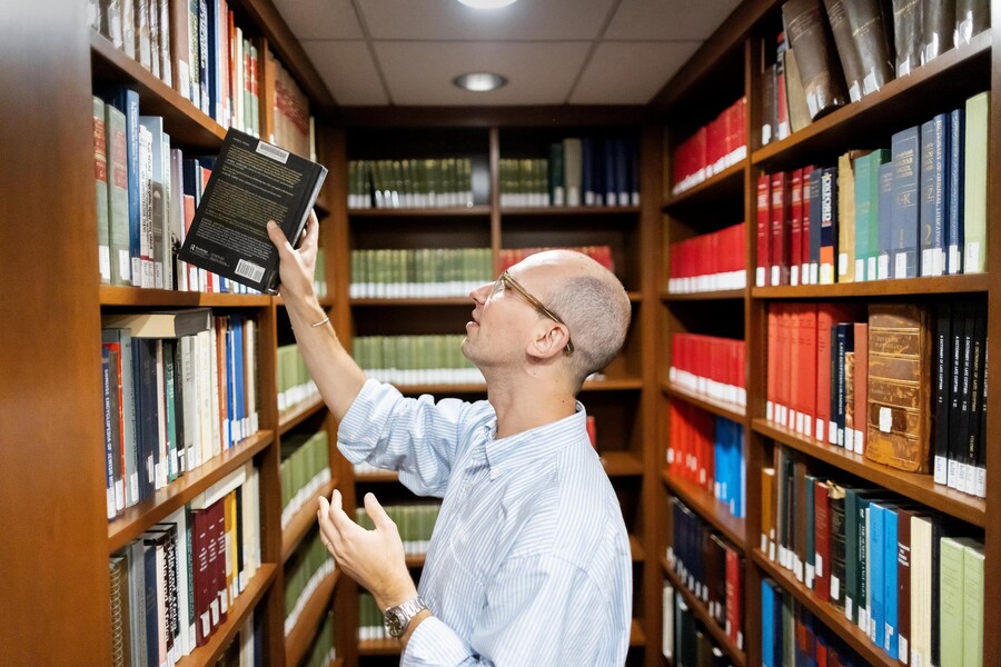 Mendel Kranz taking a book from a library shelf