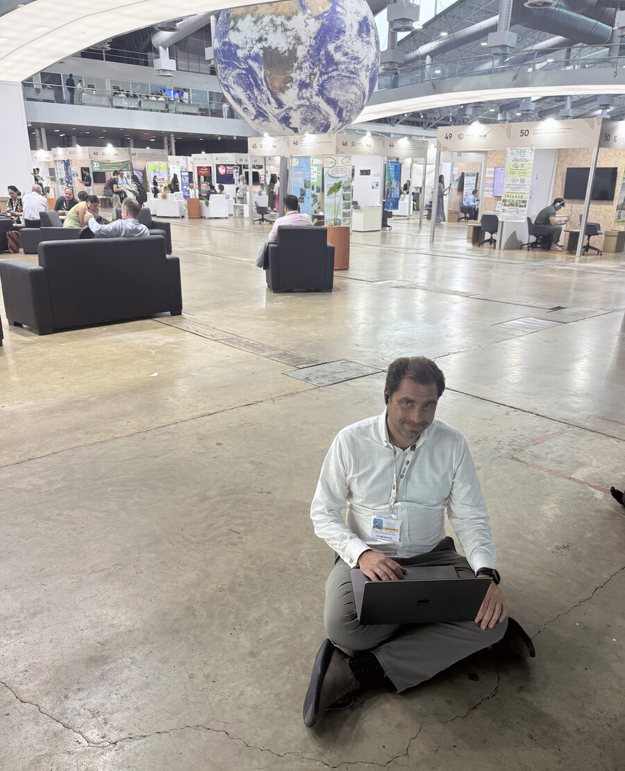 Bill Burke-White sits on floor with laptop.