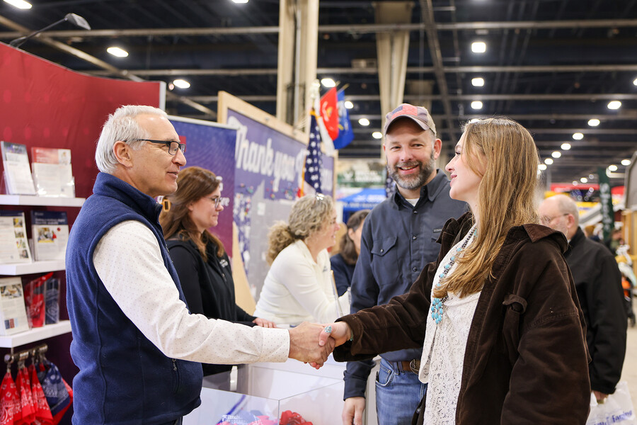 Andrew Hoffman shaking hands with Gavi Burton alongside her dad at the Pennsylvania Farm Show.