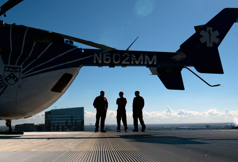 Three members of the PennSTAR flight crew next to a helicopter.