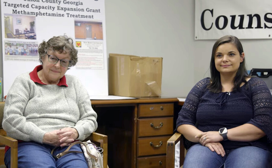 Two people seated in a community health center for an opioid training exercise.