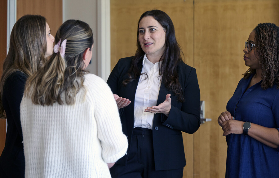 Rebecca Boswell speaking with three people.
