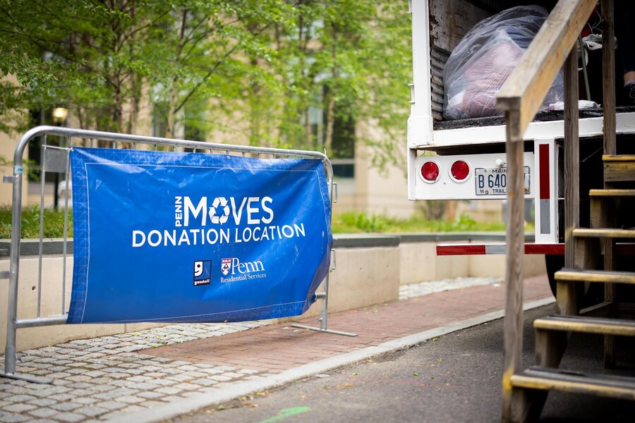 A MOVES donation location sign in front of a donation drop-off truck on Penn’s campus.